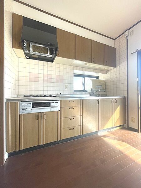 収納豊富なキッチンは、調理器具をすっきりと整理できます。窓から光が差し込み、明るい雰囲気で料理を楽しめます。