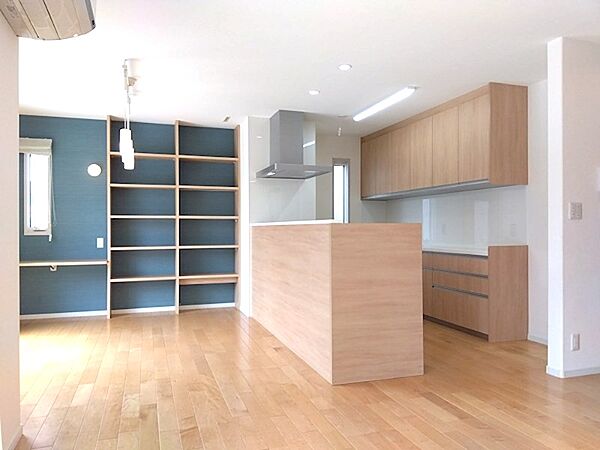 開放感のあるリビングは、キッチンとの一体型でご家族との会話も弾みます。壁一面の収納棚は、書斎や趣味の空間にも活用できます。