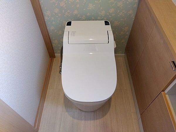 清潔感あふれるホワイトのトイレは、快適な毎日をサポートします。上品な花柄の壁紙が空間に彩りを添えています。