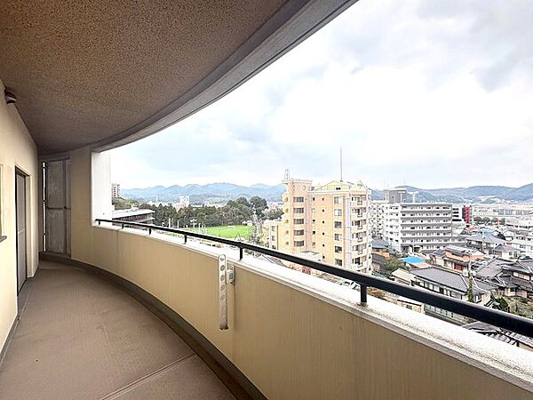 開放感のあるL字型バルコニーからは、遠くの山々や街並みを一望できます。心地よい風を感じながら、贅沢なひとときをお過ごしください。