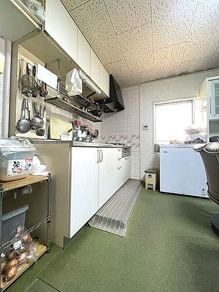 調理器具を収納できる棚があり、お料理好きの方にも嬉しいキッチンです。窓から光が差し込み、明るい空間で料理を楽しめます。