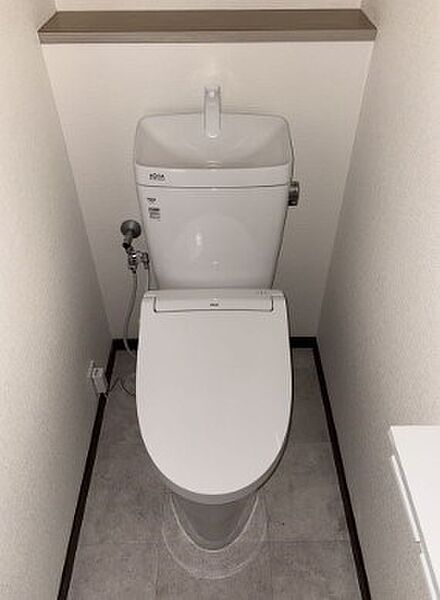 手洗い機能付きの清潔なトイレは、快適な毎日をサポートします。上部の棚には小物を置くことも可能です。