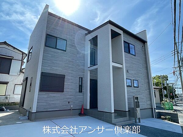 太陽が降り注ぐ明るい外観。落ち着いたグレーの外壁に白のアクセントが映える、開放感ある佇まいです。