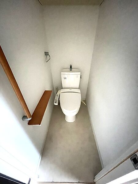 清潔感のある明るいトイレ空間です。手すりと収納に便利なカウンターを設置しました。