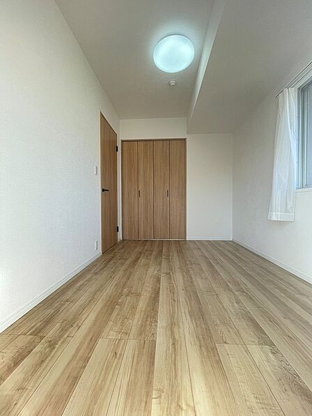 木の温もりを感じるフローリングと、明るい壁が心地よい寝室です。大容量の収納も魅力。穏やかなプライベート空間で、一日の疲れを癒しませんか。
