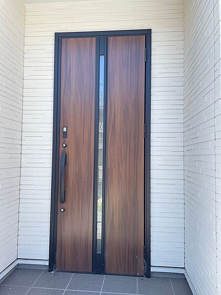 木目調のドアと白壁のコントラストが美しい玄関です。毎日を彩る明るい空間が、住まいの顔として訪れる人を温かく迎えます。