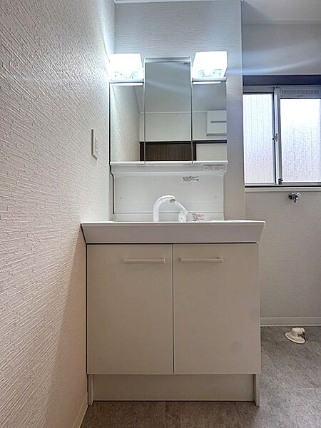 白を基調とした清潔感のある洗面台。収納付き三面鏡で朝の準備もスムーズに。小窓があり、換気も可能です。