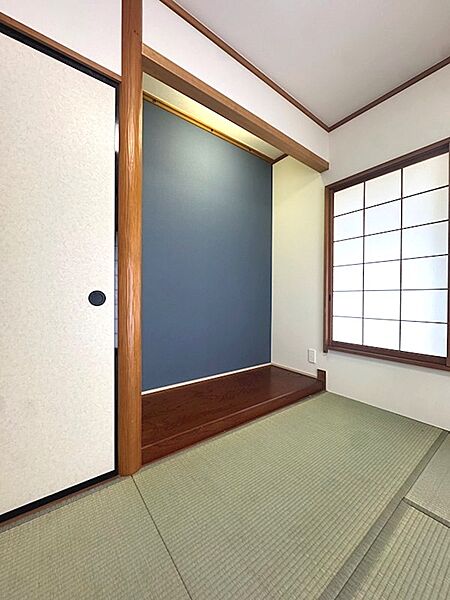 琉球畳と落ち着いたアクセントクロスが印象的な和室。窓からの光が障子を優しく照らし、穏やかな時間を演出します。
