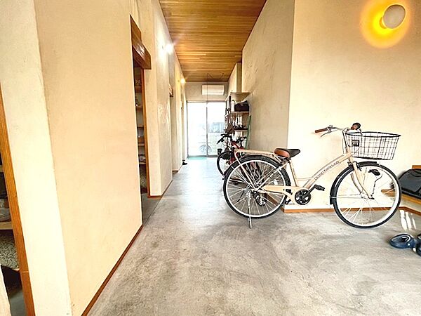 広々とした玄関は、趣味の自転車を置いてもゆとりがあります。木の温もりを感じる天井と、無機質なコンクリートの床が、心地よい空間を演出します。
