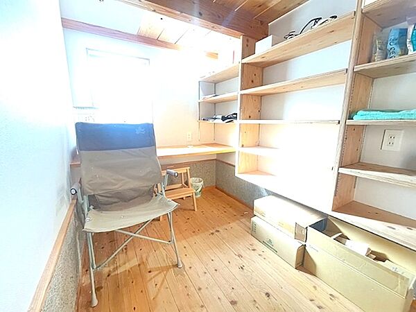 陽光が差し込む小部屋は、読書や趣味の空間に最適です。壁一面の可動棚とカウンターで、収納と作業スペースを両立できます。