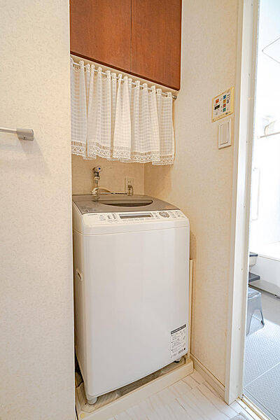 洗面室にすっきりと収まる、使い勝手の良い洗濯機スペース。上部には洗剤や小物を美しく隠せる大きな吊り戸棚が設えられ、日々の家事空間をいつも清潔に整えてくれます。毎日の洗濯が心地よくスムーズになる工夫です