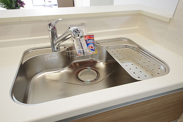 スマートな水栓は、ワンタッチで切替ができる浄水器を内蔵。ホースを伸ばしてシャワーとしても利用可。