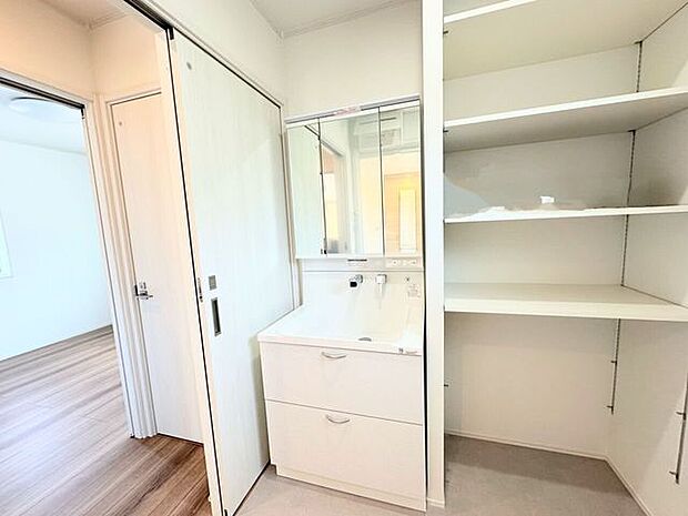 三面鏡の裏側に収納スペースを設置。化粧品や洗面小物などをすっきりと収納できます。