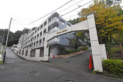 外観：緑に囲まれた静かな場所に佇む青いタイルが目印のマンション