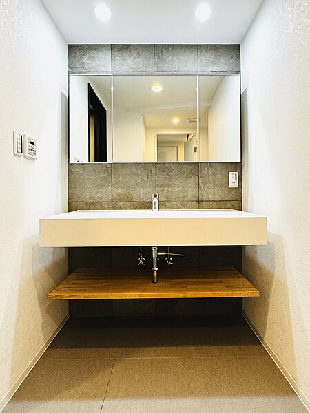 洗面所には三面鏡裏収納付き洗面化粧台を設置しており収納スペースが豊富。