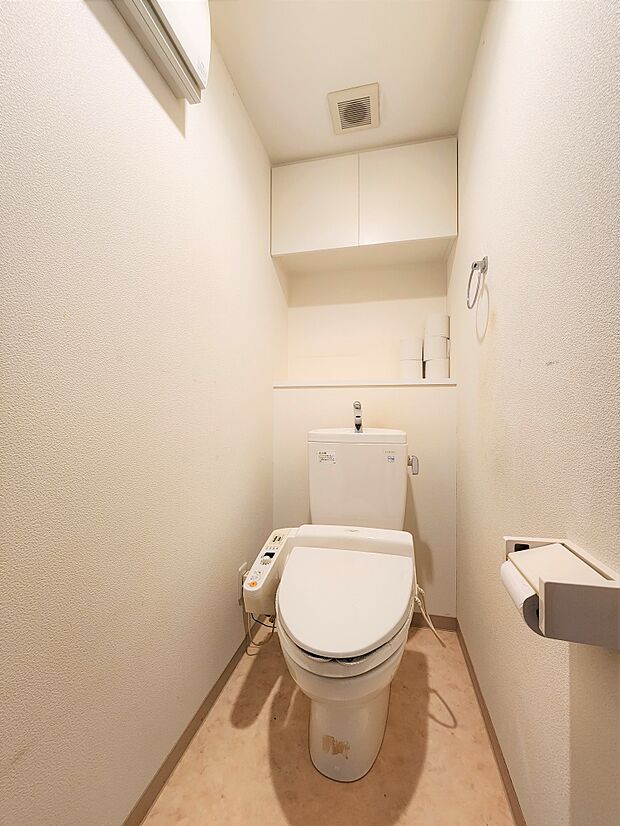 トイレ　温水洗浄便座付。上部吊戸棚付。