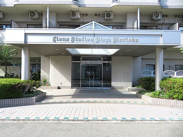 エントランス前外観写真　トップライトからの明かりが降り注ぐキャノピーが特徴的