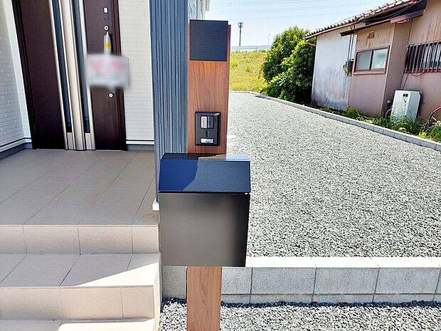 玄関前には一体型で場所を取らない、お洒落なカメラ付インターホン・ポストがあり表札も付けることが可能