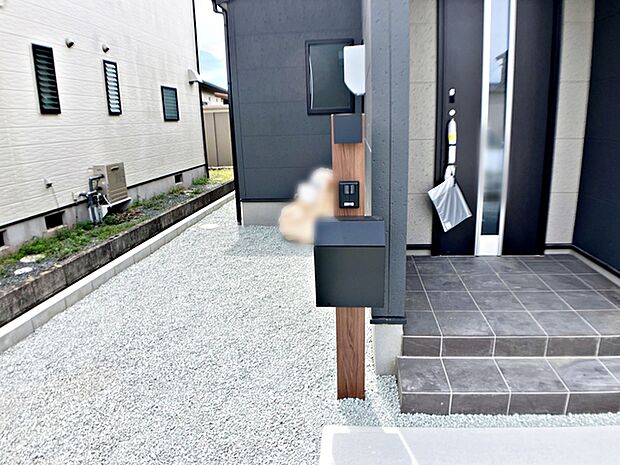玄関前にはカメラ付インターホンとポストの一体型設備が設置されており、省スペースで玄関まわりがすっきりとまとまります。来訪者の確認や郵便物の受け取りもスムーズに行える、使い勝手の良い玄関まわりです。 