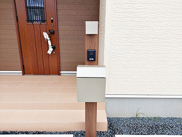 玄関前にはカメラ付インターホンとポストが一体型で設置されており、省スペースで玄関まわりがすっきりとまとまります。来訪者の確認や郵便物の受け取りもスムーズに行える、使い勝手の良い設備です。 