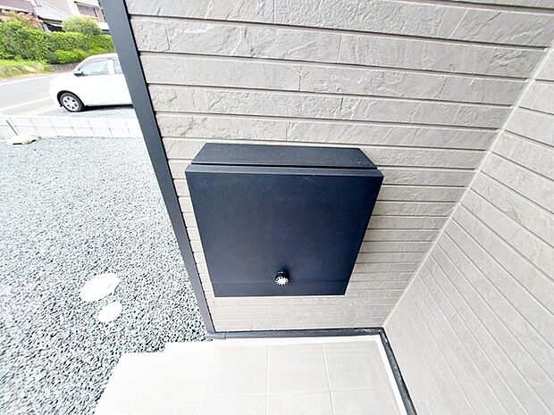 玄関ポーチ内に設置されたポストで、雨の日でも濡れずに郵便物を取り出すことができます。庇に守られた位置にあるため、天候を気にせずスムーズに受け取りができるのが特徴です。毎日の使い勝手に配慮されています。