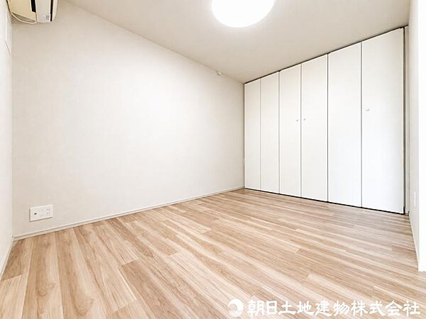 【居室】木目調の建具と明るいフローリングが調和した、落ち着きのある洋室。