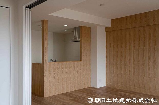 対面キッチンの壁には天然木材を使用し、従来のクロス仕上げとは一線を画す上質な仕上がりです。自然の温かみが空間に心地よい雰囲気をもたらします