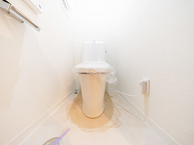 白を基調とした明るく清潔感のある空間に設置されたトイレ。今回のリフォームで温水洗浄便座付のものに交換をしました。
