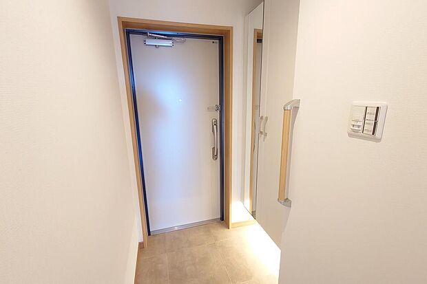 白色を基調とした玄関です。意外とあると便利な手すりも設置済み。