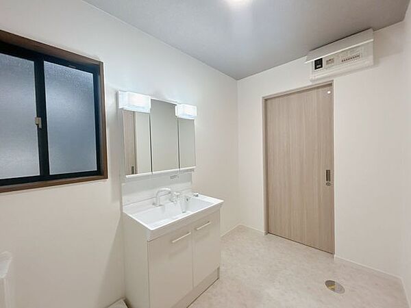 【リフォーム済】洗面脱衣質です。洗面化粧台はLIXIL製のものに新品交換いたしました。三面鏡タイプを採用いたしますので見た目もよく、収納力もばっちりです。