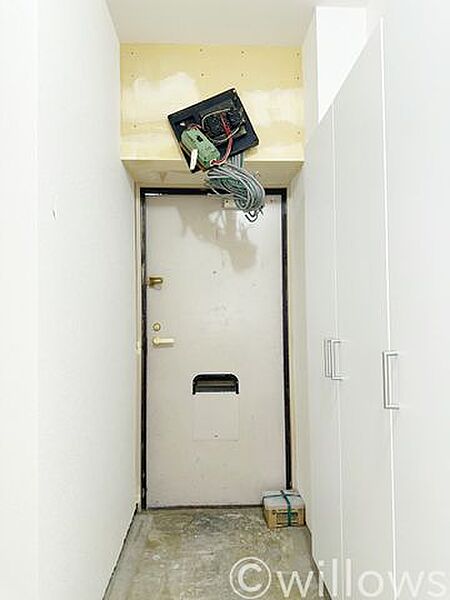 玄関エリアの施工中の様子です。配線処理や内装仕上げの工程中ですが、高さのある大容量シューズボックスが設置されており、完成後は靴や小物をすっきりと収納できる使い勝手の良い空間に仕上がります。