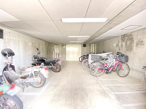 【バイク置き場・駐輪場】屋内にあるバイク・自転車置場は雨の日も安心です。区画毎に白線が引かれていて、駐輪位置が分かりやすく助かります。空き状況や月額利用料金についてはお気軽にお尋ねください。