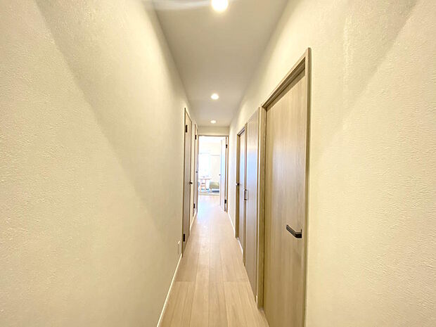【廊下】ナチュラルな色合いのフローリングと白を基調としたクロスが清潔感ある空間です。廊下は、ご家族が集う南向きのLDKにつながります。２０２４年２月リノベーション済のため新生活も安心ですね♪