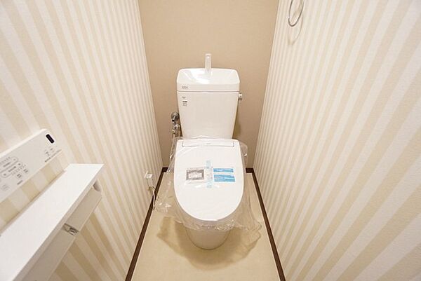 壁リモコンタイプのウォシュレット付き。すっきりした見た目で、トイレ奥の掃除もしやすいです。上部には収納棚が付いています＾＾