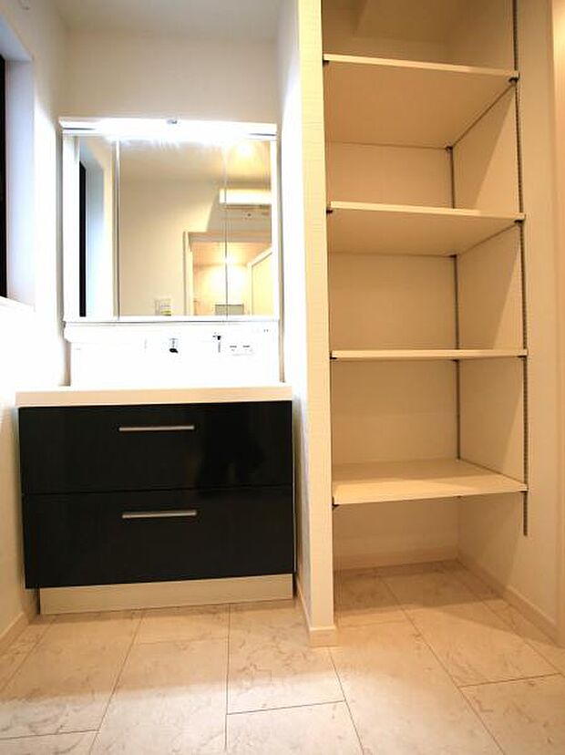 三面鏡の裏は機能的な収納を配置。コンセントも付いているため電動シェーバーや電動歯ブラシも収納できます。横には小窓や収納棚もあります。