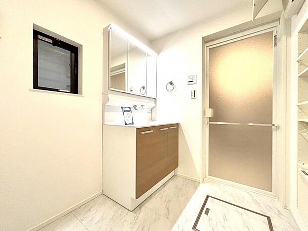 三面鏡の裏は機能的な収納を配置。コンセントも付いているため電動シェーバーや電動歯ブラシも収納できます。小窓が付いたパウダールームです。