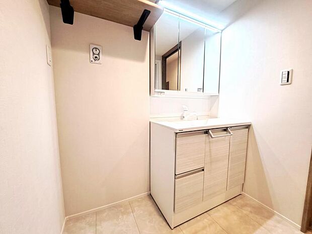 三面鏡の裏は機能的な収納を配置。コンセントも付いているため電動シェーバーや電動歯ブラシも収納できます。