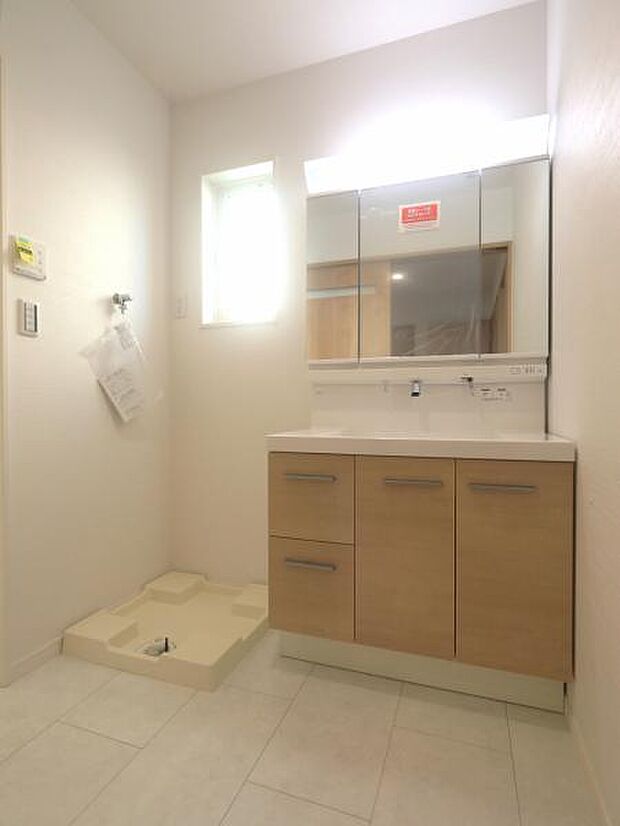 三面鏡の裏は機能的な収納を配置。コンセントも付いているため電動シェーバーや電動歯ブラシも収納できます。小窓が付いたパウダールームです。