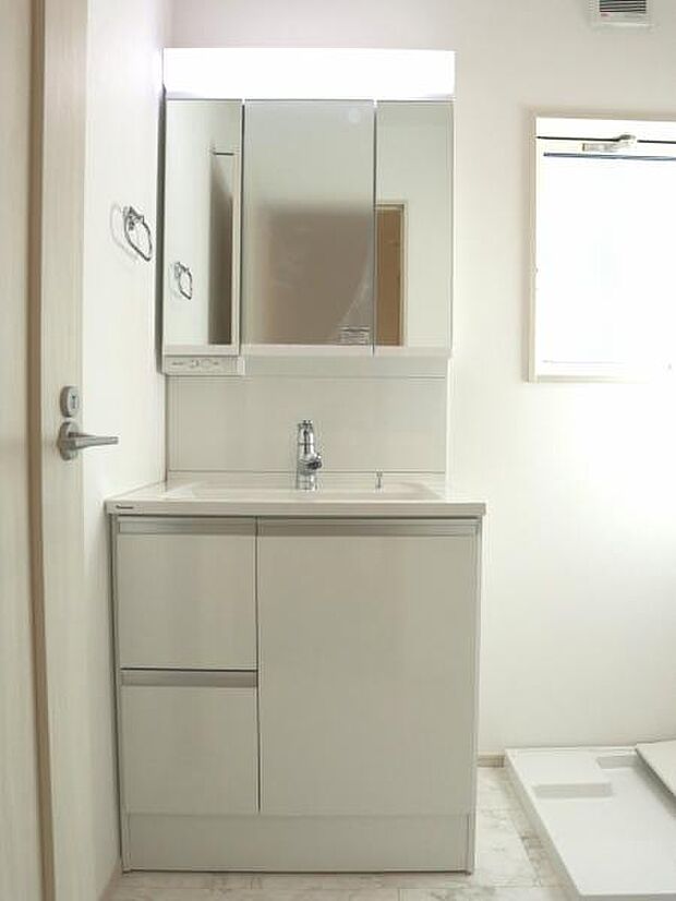 三面鏡の裏は機能的な収納を配置。コンセントも付いているため電動シェーバーや電動歯ブラシも収納できます。