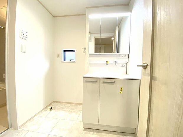 小窓が付いたパウダールームです。三面鏡の裏は機能的な収納を配置。コンセントも付いているため電動シェーバーや電動歯ブラシも収納できます。