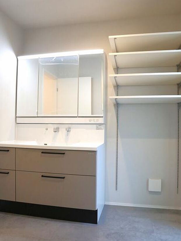 三面鏡の裏は機能的な収納を配置。コンセントも付いているため電動シェーバーや電動歯ブラシも収納できます。