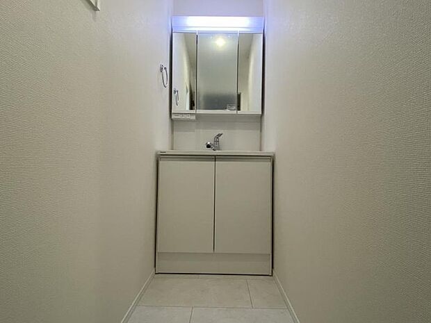 三面鏡の裏は機能的な収納を配置。コンセントも付いているため電動シェーバーや電動歯ブラシも収納できます。小窓が付いたパウダールームです。