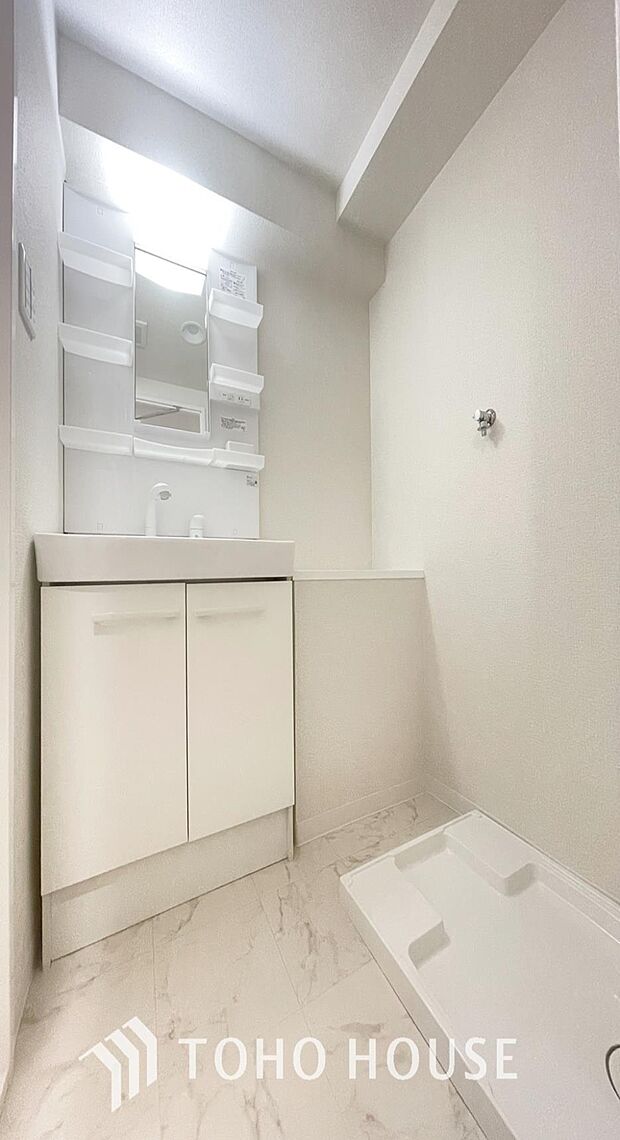 「清潔な印象の洗面室」明るく清潔感のある色調で纏められた洗面室は、機能性に富んだ三面鏡と使い勝手の良い収納を完備した洗面台を設置。洗濯機置場も完備し、大変充実しております。