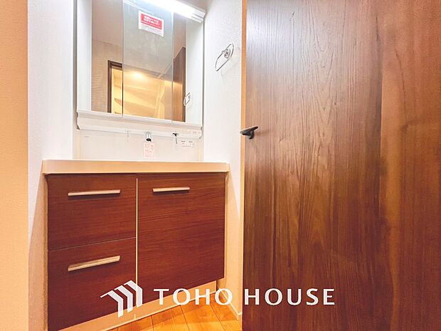 「洗面化粧台」白を基調とした清潔感溢れるデザインの洗面化粧台です。三面鏡の裏側や足元のキャビネットなど、収納豊富で実用的な洗面空間です。