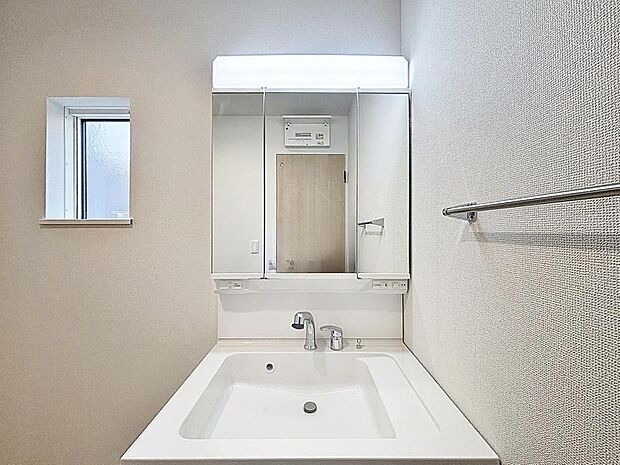 「シャワー機能付き洗面室」明るく清潔感のある色調で纏められた洗面室は、機能性に富んだ三面鏡と使い勝手の良い収納を完備した洗面台を設置。洗濯機置場も完備し、大変充実しております。