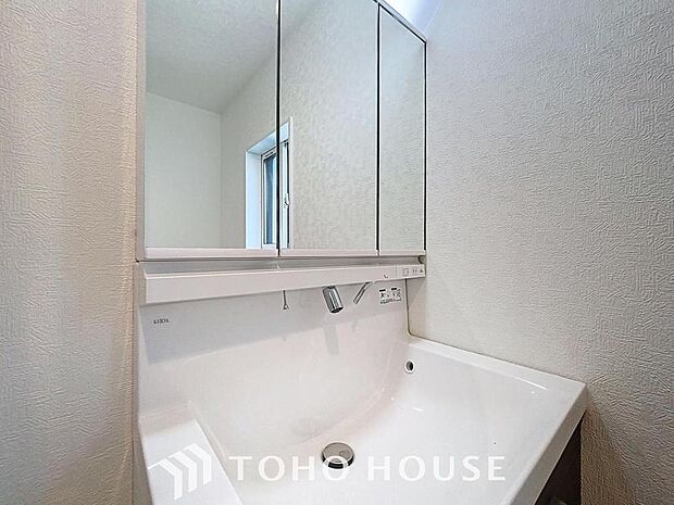 「清潔な印象の洗面室」明るく清潔感のある色調で纏められた洗面室は、機能性に富んだ三面鏡と使い勝手の良い収納を完備した洗面台を設置。洗濯機置場も完備し、大変充実しております。