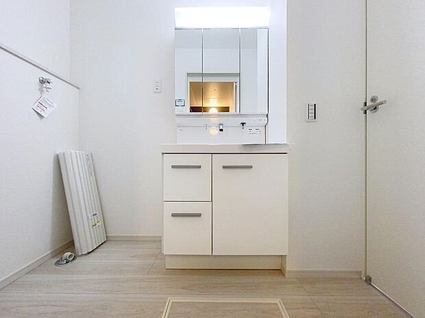 「清潔な印象の洗面室」明るく清潔感のある色調で纏められた洗面室は、機能性に富んだ三面鏡と使い勝手の良い収納を完備した洗面台を設置。洗濯機置場も完備し、大変充実しております。