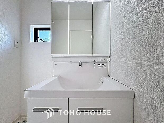 「清潔な印象の洗面室」明るく清潔感のある色調で纏められた洗面室は、機能性に富んだ三面鏡と使い勝手の良い収納を完備した洗面台を設置。洗濯機置場も完備し、大変充実しております。