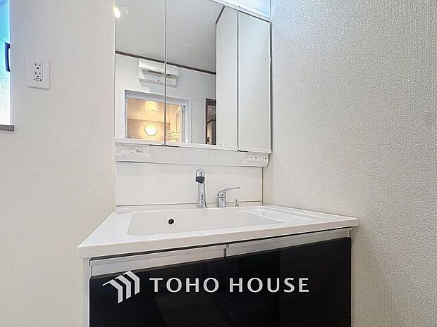 「清潔な印象の洗面室」明るく清潔感のある色調で纏められた洗面室は、機能性に富んだ三面鏡と使い勝手の良い収納を完備した洗面台を設置。洗濯機置場も完備し、大変充実しております。