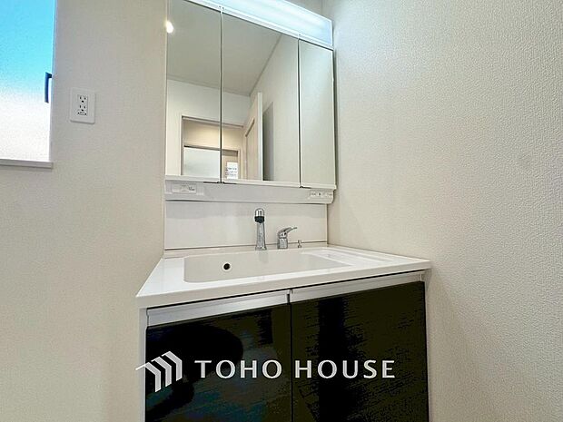 「清潔な印象の洗面室」明るく清潔感のある色調で纏められた洗面室は、機能性に富んだ三面鏡と使い勝手の良い収納を完備した洗面台を設置。洗濯機置場も完備し、大変充実しております。